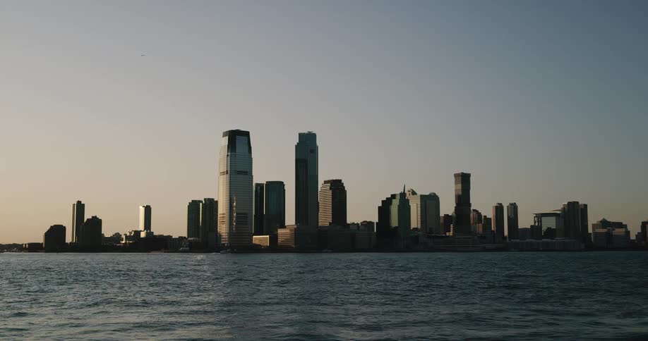 A large city with several skyscrapers is located next to a large body of water