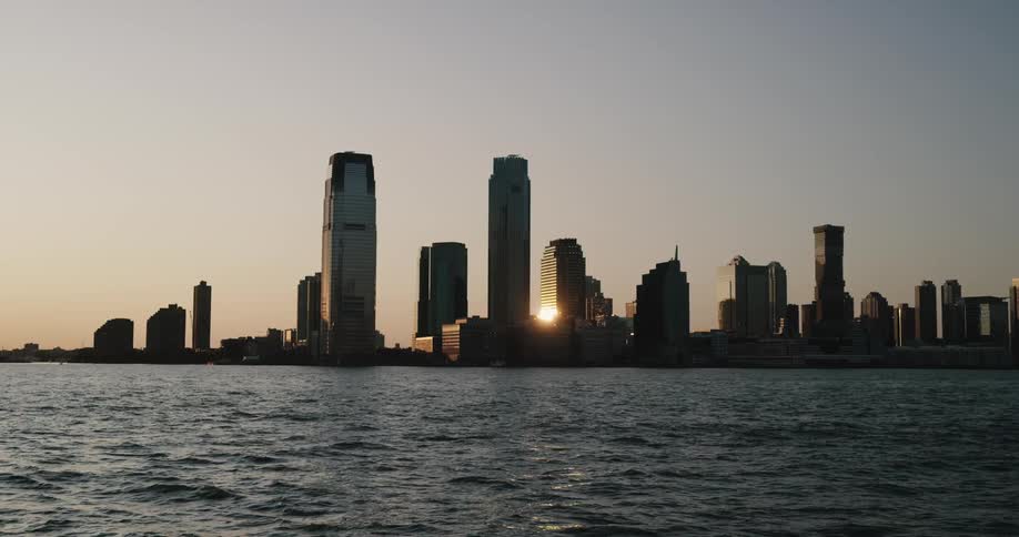 A waterfront city is illuminated by the morning sun