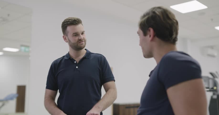 A man is explaining a knee brace to another man