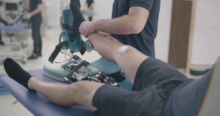 A medical personnel puts a patients leg in a special leg brace