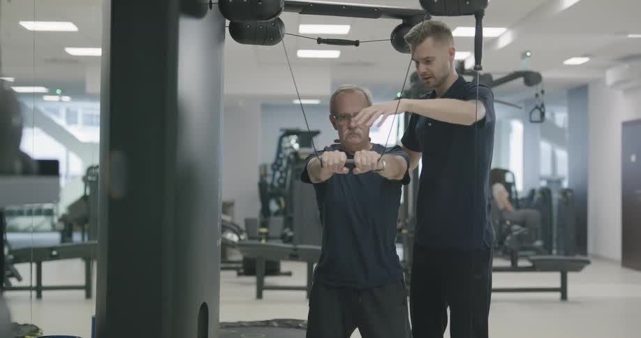 A trainer helping a man work out
