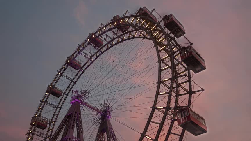 Ferris wheel turns as clouds pass overhead