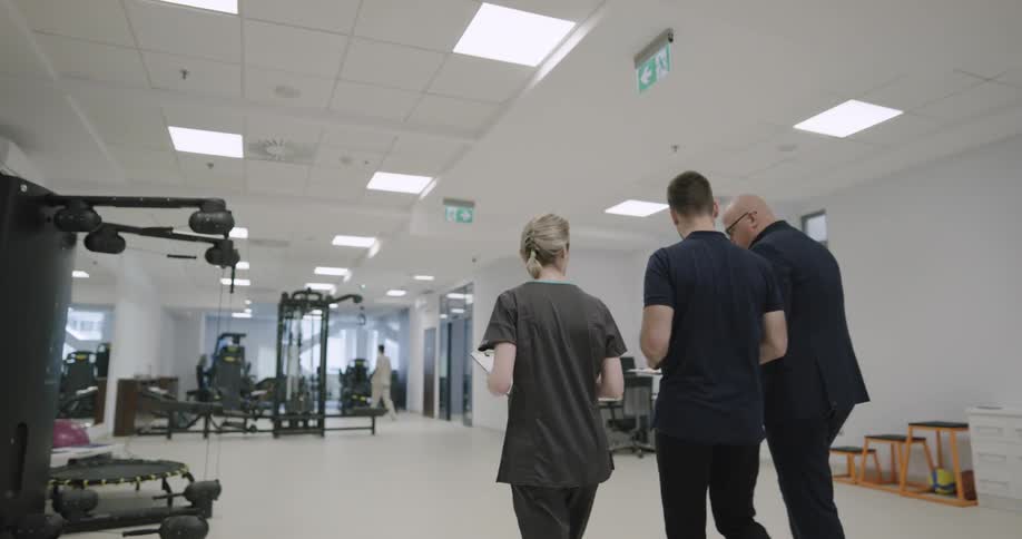People talking as they walk through a physical therapy clinic