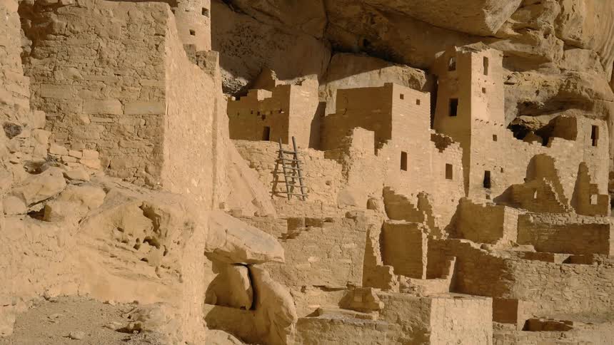 A cliff dwelling is illuminated on a sunny day