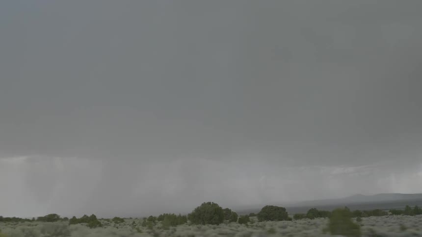 Dark skies and fog loom above an empty field