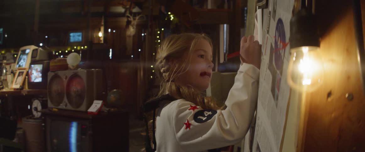 A girl with nasa suit write something on the wall