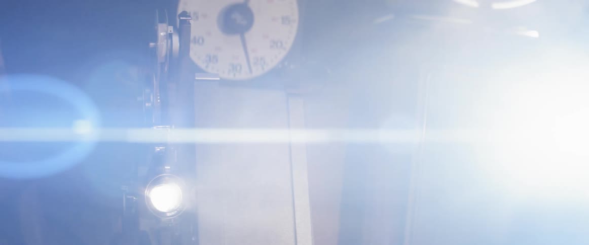 A film projector emitting bright light into a dark room