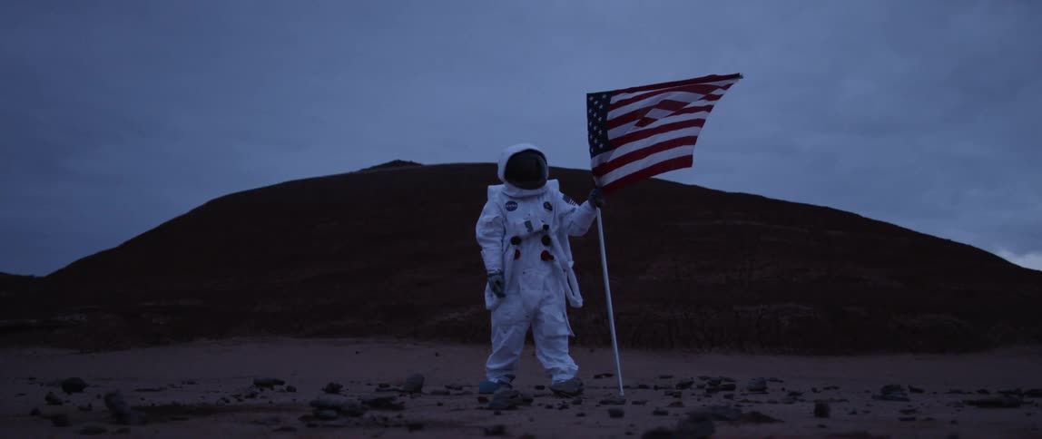 An astronaut put american flag on the land