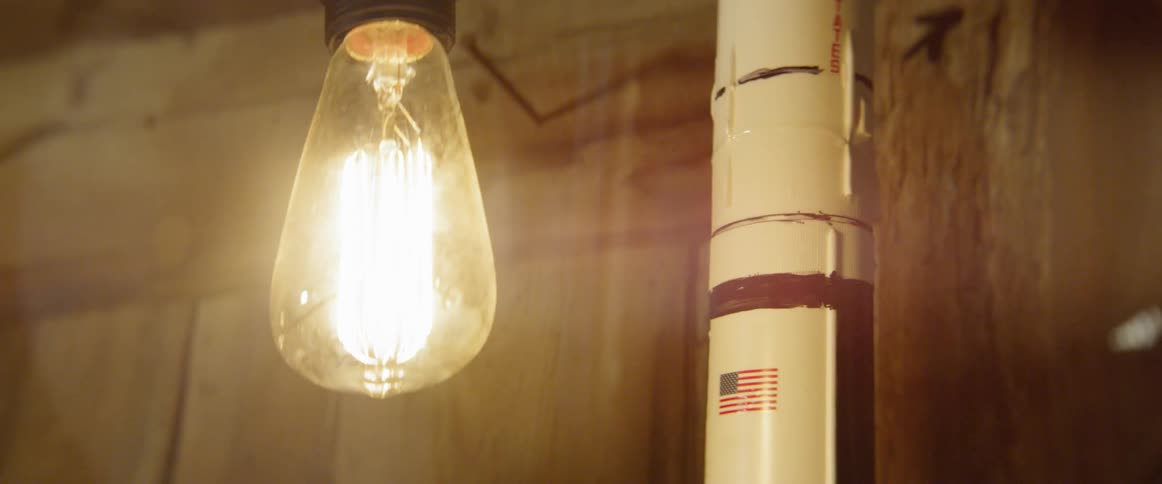 The light bulb flares in the dark room