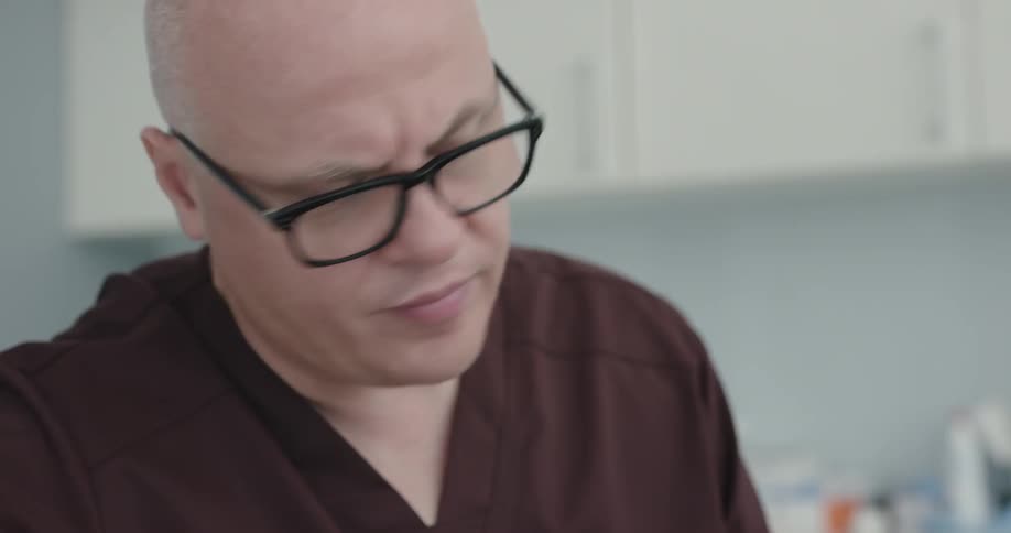 A bald doctor with glasses explaining something