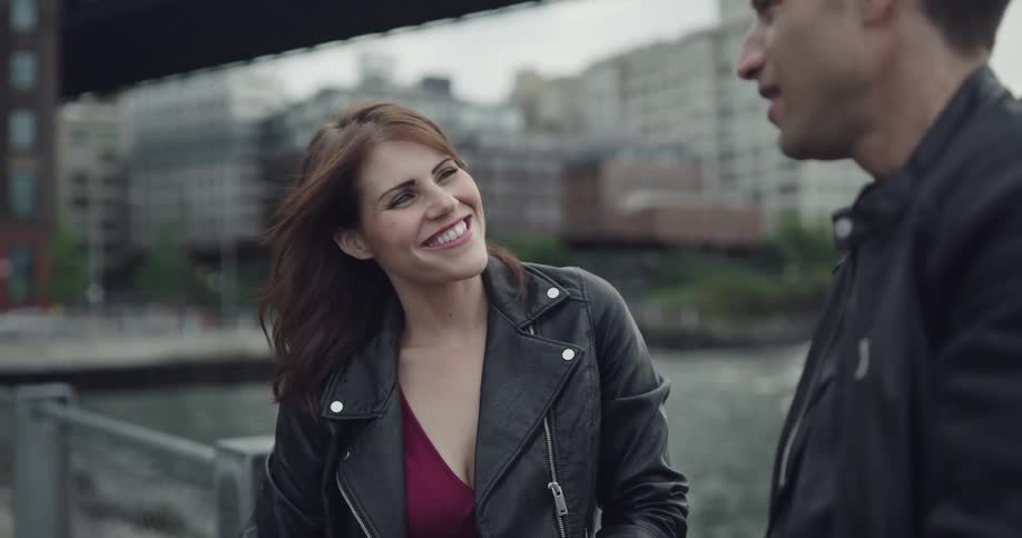 Couple lean near waterfront talking