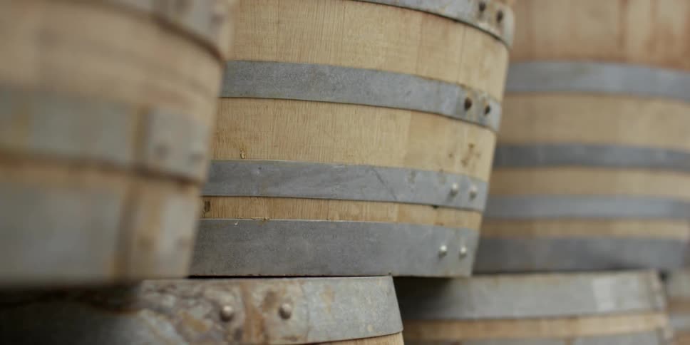 Barrels are stacked and lined up on a sunny day