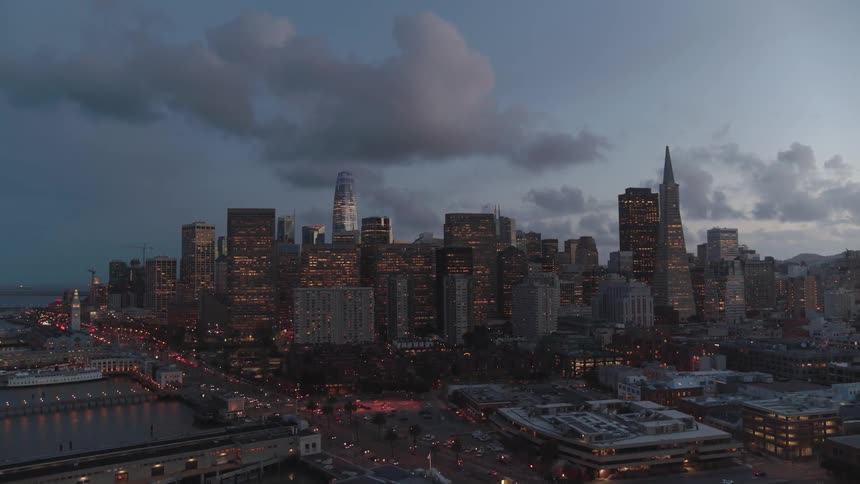 Skyline of the illuminated city with tall buildings at dusk