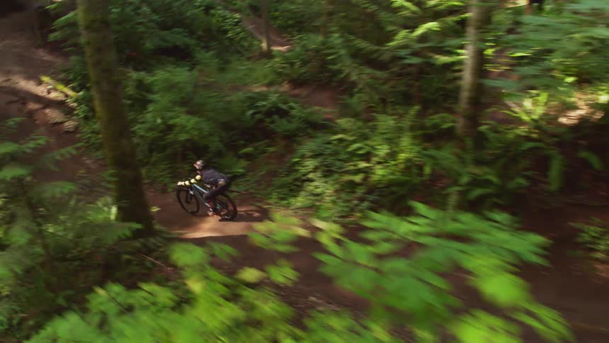 A person jumps off a ramp on a mountain bike