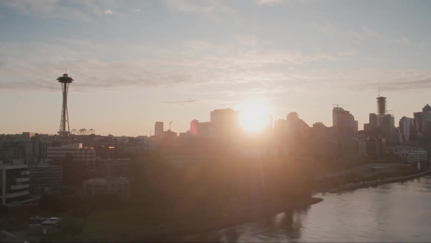 The river sits next to the city under a cloudy blue sky
