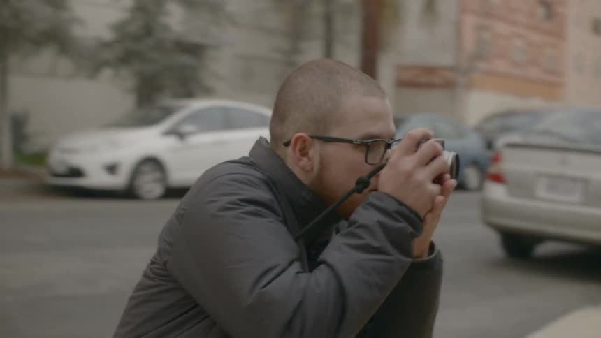 A man quickly bends down to take a picture