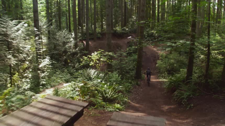 Man biking down hill at the forest