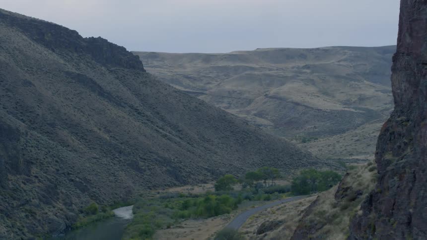 An aerial view of a grassland between mountains