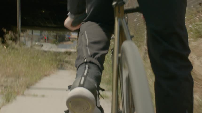 A man rides his bike on a city sidewalk