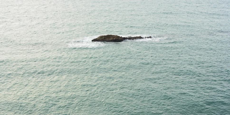 The waves crash against the rocks in the ocean