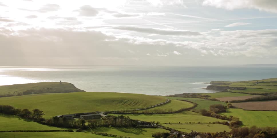 Green fields lie before the ocean
