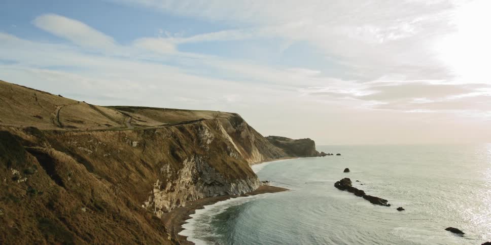 Cliffside view of gentle waves lapping at the shoreline