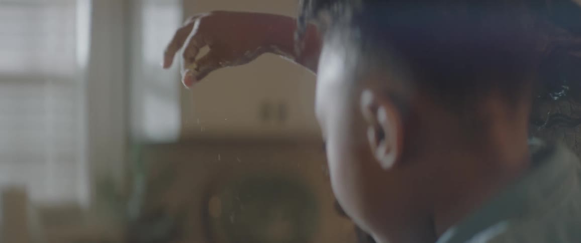 A young girl picks up powder and drops it