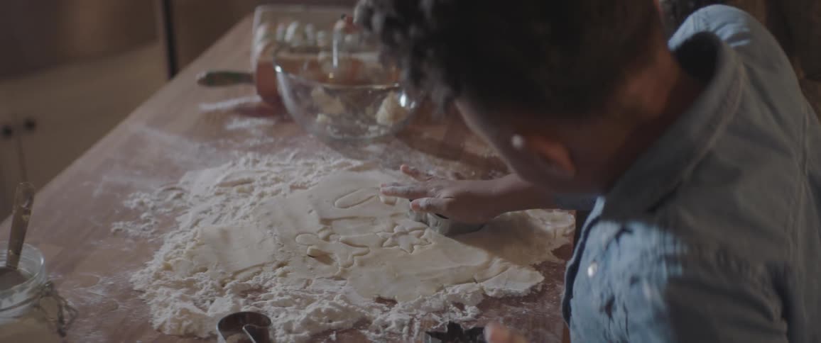 Girl play with the cookie mold with her mother