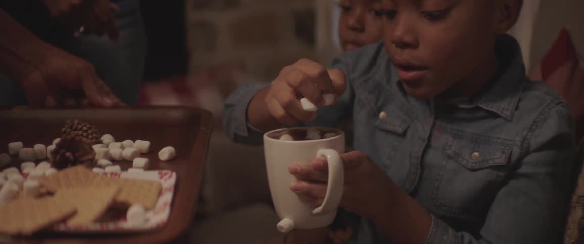Girl put marshmallow in her hot chocolate