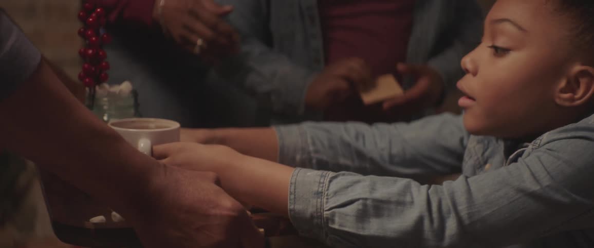 A girl taking a coffee mug from a tray holding smores