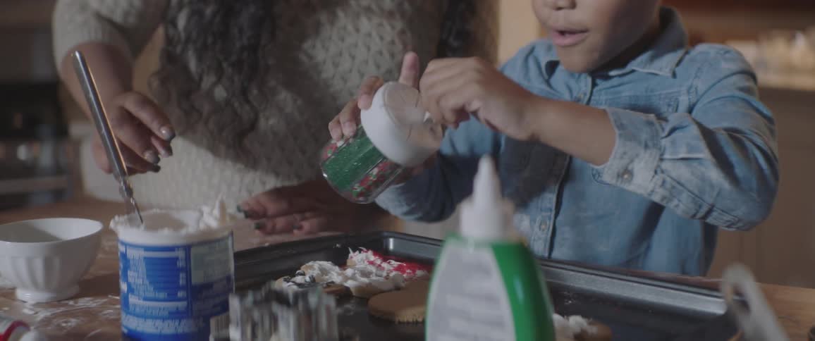 A child and mother make cookies together