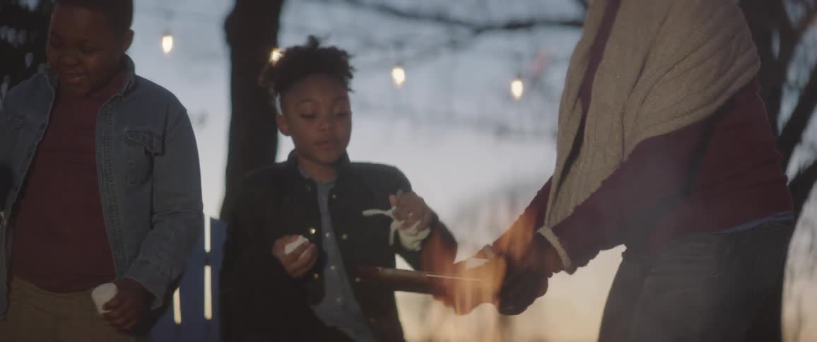 People eating marshmallows by the fire