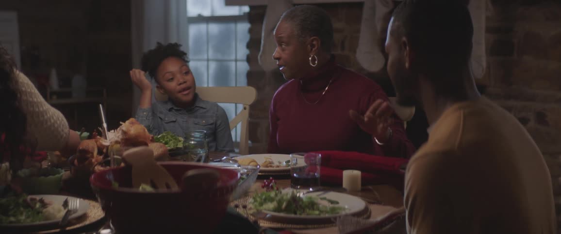 A family sits at the table talking and eating