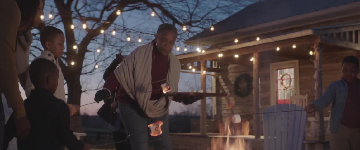 People grill marshmallows over a campfire