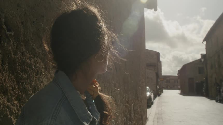 A woman is outdoors looking around