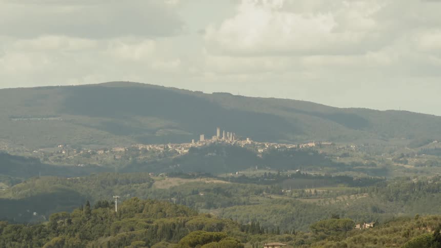 A city is nestled between some tree covered hills