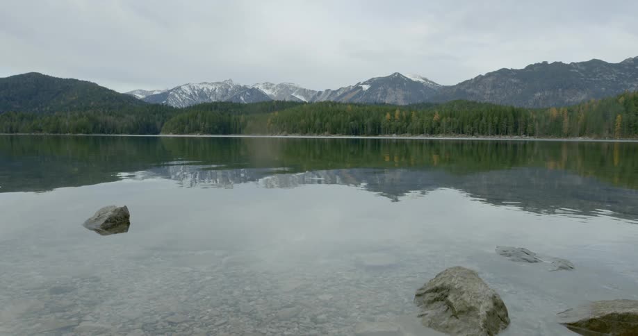 A scenery of a calming lake with mountain background