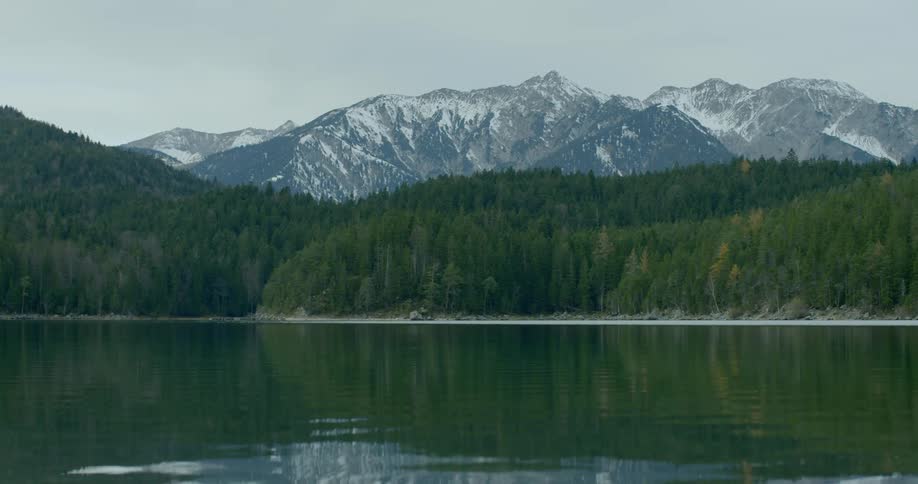 Landscape view of a lake in front of a forest and mountains