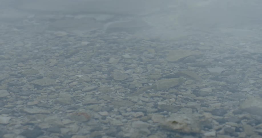 Clear water ripples over stone covered river bottom