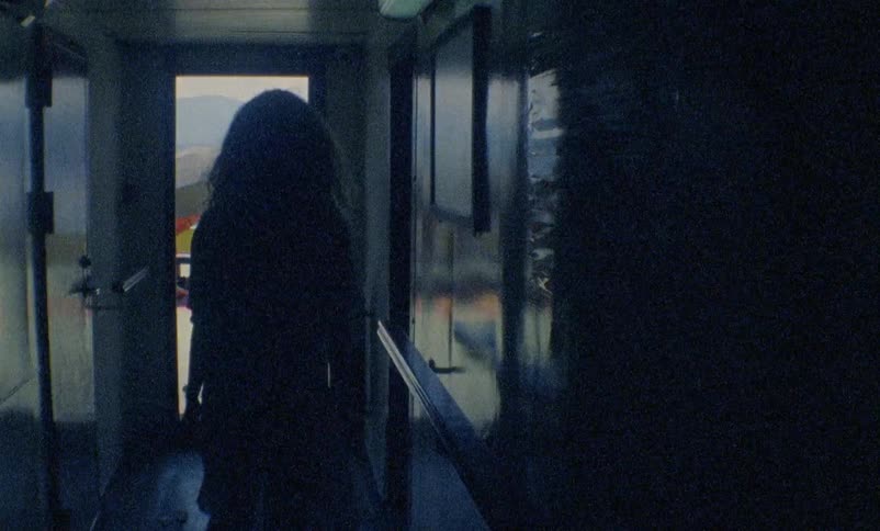 A woman wearing a dress walks down a hallway