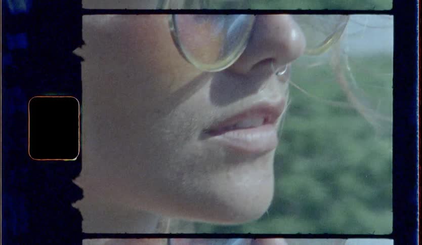Blonde woman wearing sunglasses and nose ring looks ahead on a mountain during daylight