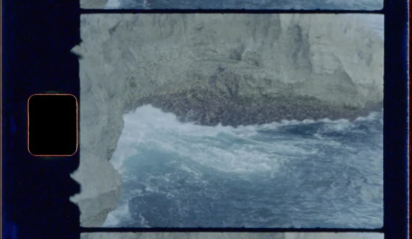 The large waves crash against the rocks