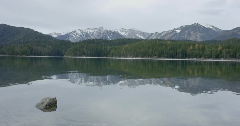 A scenery of a calming lake with snowy mountain