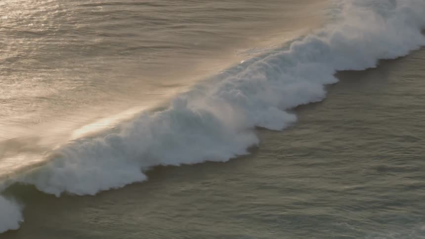 The ocean waves roll into shore