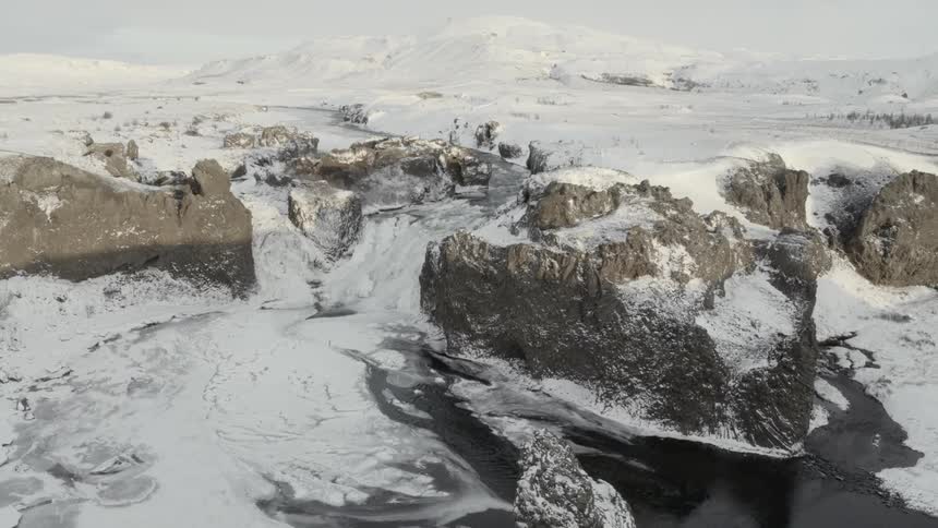 The rocks below by the shore are covered with ice