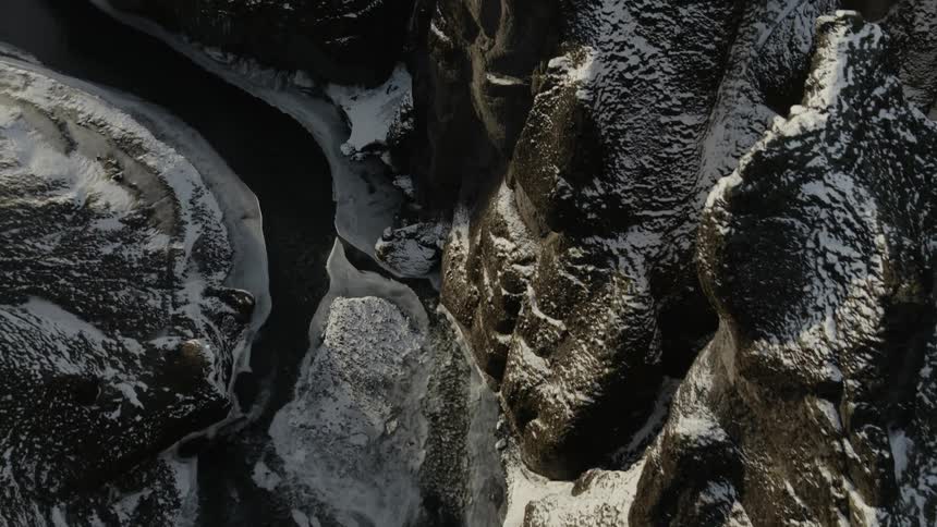 An aerial view of a rocky and snowy mountain