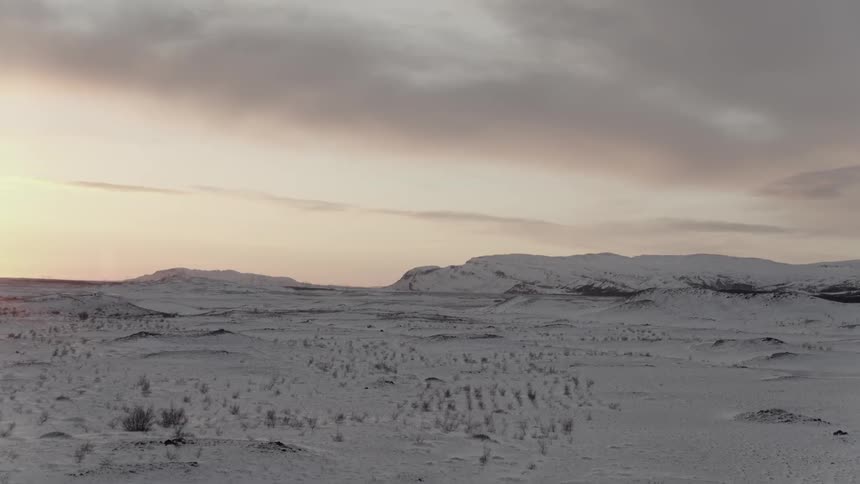 A barren field is covered with snow