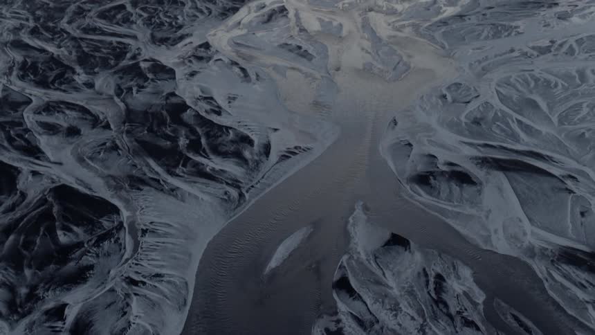 A river flows between snow covered land