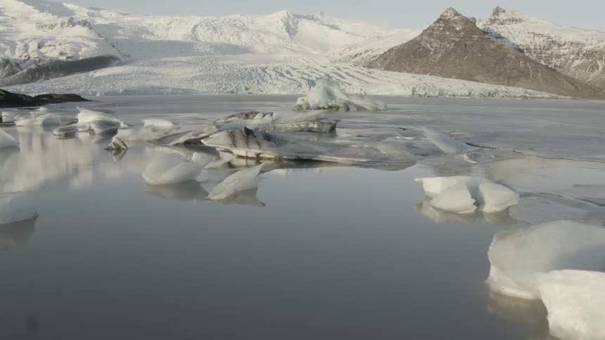 The ice is floating near the snow filled shore