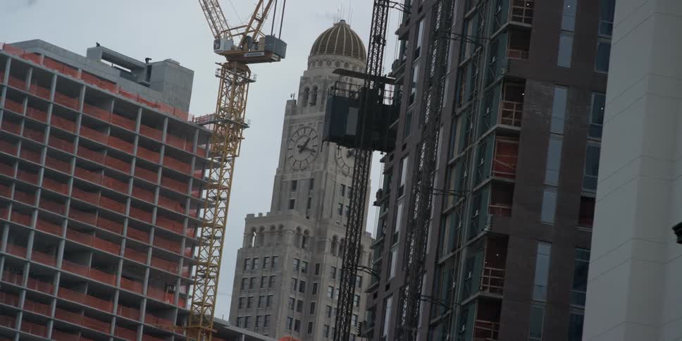 A crane stands near tall city buildings